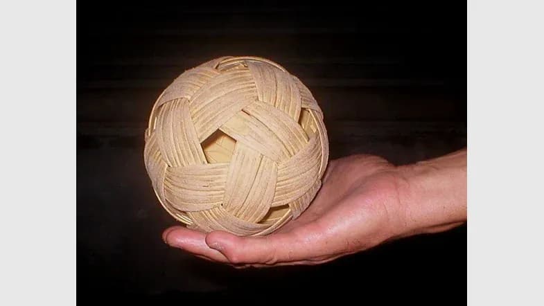 Quả bóng cầu mây bằng mây đan đặt trên bàn tay